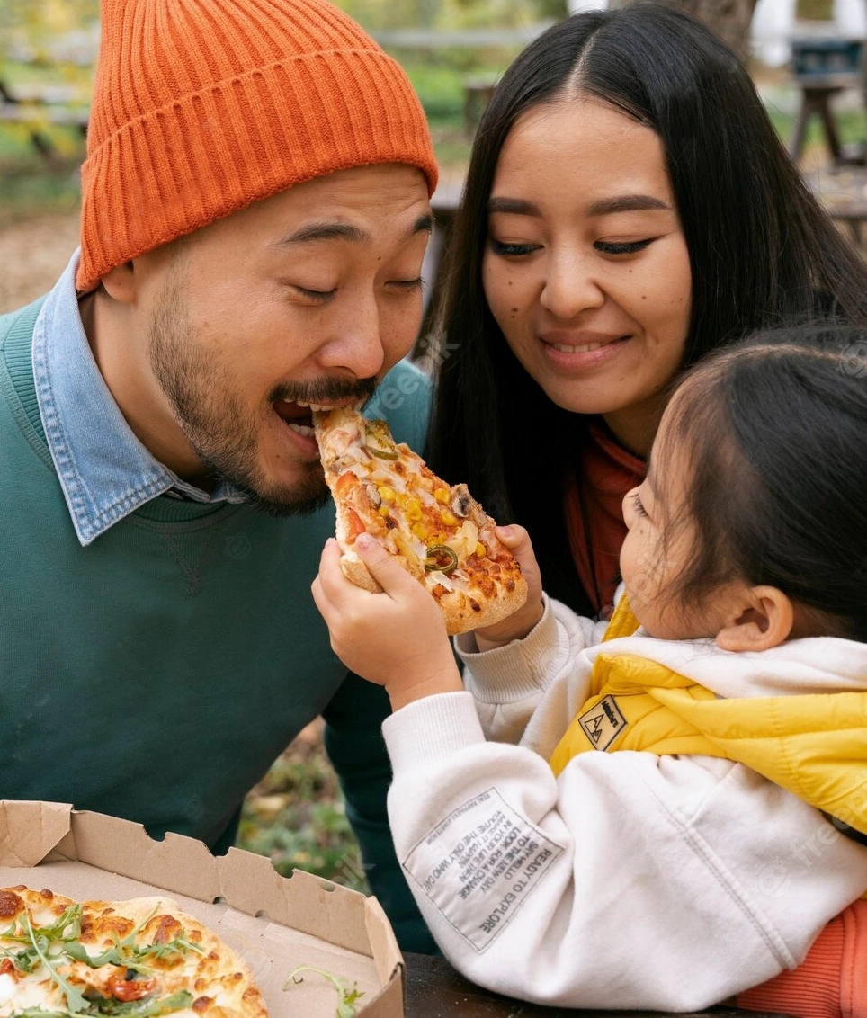 A little boy eating a big pizza and drinking water